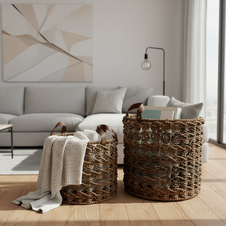 Set of two handwoven open-weave storage baskets with rich natural fibres and genuine leather handles, styled with a knitted throw and books in a contemporary living room, offering stylish storage while adding warm organic texture and artisanal charm to modern, coastal, and rustic interiors.