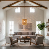 Handwoven natural rattan drum pendant light with an open woven design, casting beautiful patterned shadows in a contemporary living room with exposed timber beams and neutral décor.
