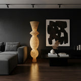 Tall sculptural floor lamp featuring a handwoven natural wicker shade with an elegant stacked silhouette that softly diffuses warm ambient light. A striking statement lighting piece perfect for living rooms, bedrooms, boutique hotels, and contemporary interiors.