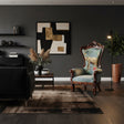 Luxury accent chair featuring a hand-carved dark wood frame, soft sage green upholstery, and a decorative high back showcasing an elegant elephant illustration with botanical details. A timeless statement piece for sophisticated living spaces, boutique hotels, or executive lounges.