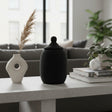 Handcrafted decorative urn featuring a matte black beaded finish with a matching fitted lid and rounded finial. A sophisticated artisan décor piece that adds texture, elegance, and contemporary African-inspired style to consoles, shelves, coffee tables, and luxury interiors.