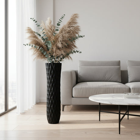 Tall contemporary floor vase with a black textured geometric finish, styled with dried pampas grass and eucalyptus stems. A sophisticated statement décor piece perfect for living rooms, entryways, boutique hotels, offices, or modern minimalist interiors.