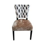 Contemporary dining chair featuring a black and cream abstract patterned upholstered backrest, a soft taupe velvet seat, and sleek black wooden legs, designed to add modern elegance and comfort to any dining space.