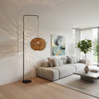 Contemporary arc floor lamp featuring a sleek black metal frame and a handwoven spherical rattan shade with a textured natural finish. The sculptural design casts beautiful decorative light patterns, making it a striking statement lighting piece for living rooms, reading corners, boutique hotels, and modern interiors.