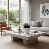 Modern square coffee table with a travertine-look finish, featuring a clean architectural pedestal base and minimalist design. Perfect for living rooms, luxury homes, boutique hotels, or contemporary interiors, offering timeless elegance and understated sophistication.