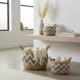 Woven baskets with zigzag patterns on a shelf and floor in a bright room.