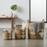 Three woven baskets with geometric patterns on a light wooden floor.