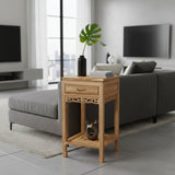 Wooden side table in a modern living room with gray sofa and large windows.