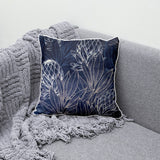Decorative navy blue scatter cushion featuring elegant protea flowers and botanical linework in soft silver and white tones, finished with contrasting light piping.