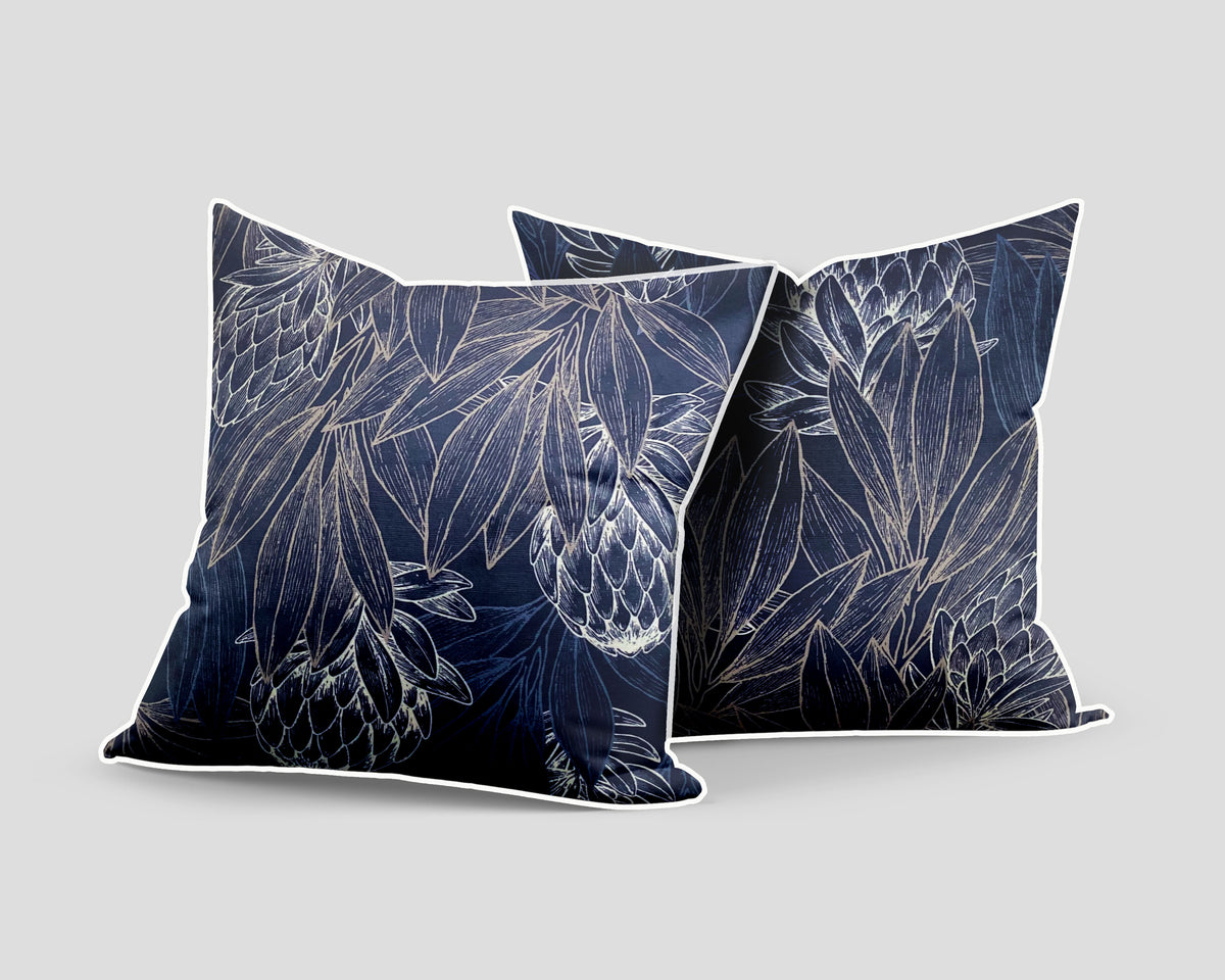 Set of three decorative navy blue scatter cushions featuring elegant protea flowers and botanical linework in soft silver tones, finished with contrasting light piping.