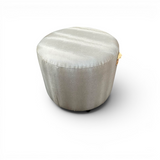 Ivory upholstered round ottoman with a minimalist design, ideal as a footrest, occasional seat, or modern accent piece for living rooms and bedrooms.