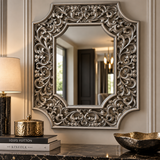 Rectangular wall mirror with an ornate silver frame featuring intricate floral scrollwork and curved corners.