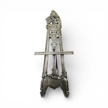 Handcrafted vintage-style wooden display easel with intricate carved detailing, distressed grey finish, and adjustable support, ideal for displaying artwork, mirrors, signage, or decorative pieces.