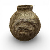 Handcrafted round woven natural fibre basket with a sculptural bulb shape and narrow opening, ideal for adding organic texture to modern interiors.