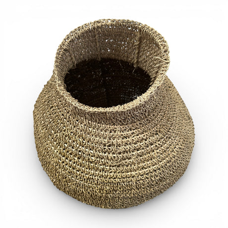 Handcrafted round woven natural fibre basket with a sculptural bulb shape and narrow opening, ideal for adding organic texture to modern interiors.