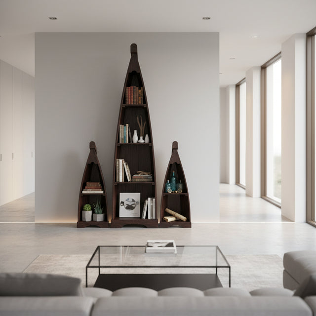 Set of three handcrafted canoe-shaped display shelves in a dark stained wood finish, styled with books, plants, bottles, and decorative accessories to create a striking focal point in a contemporary living space.