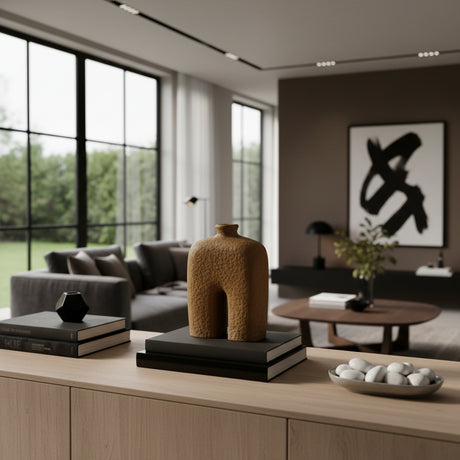 Sculptural stoneware vase with a textured earthy finish, featuring a minimalist arched silhouette and narrow neck. A contemporary decorative accent that adds warmth, organic texture, and modern style to coffee tables, shelves, consoles, or styled interiors.