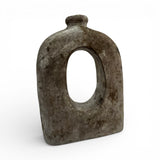 Sculptural stoneware vase with a weathered grey finish, featuring a rounded silhouette, large oval cut-out centre, and short cylindrical neck. This handcrafted contemporary vase adds organic texture and artistic character to console tables, shelves, coffee tables, and modern interiors.