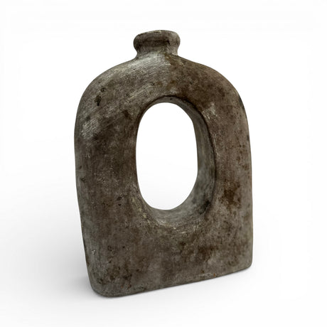 Sculptural stoneware vase with a weathered grey finish, featuring a rounded silhouette, large oval cut-out centre, and short cylindrical neck. This handcrafted contemporary vase adds organic texture and artistic character to console tables, shelves, coffee tables, and modern interiors.