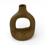Sculptural stoneware vase with a warm earthy brown finish, featuring a rounded teardrop silhouette, large oval cut-out centre, and a narrow neck. This handcrafted contemporary vase adds organic texture and sculptural elegance to console tables, shelves, coffee tables, or modern interiors.