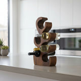 Sculptural handcrafted teak wood wine rack with six curved bottle holders, styled with wine bottles on a modern kitchen countertop. Featuring a rich natural wood finish, this contemporary wine rack offers elegant storage and serves as a striking decorative accent for kitchens, dining rooms, or home bars.