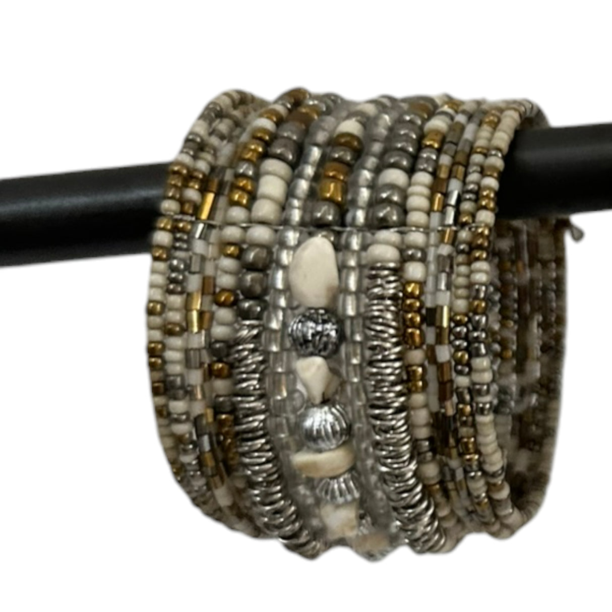 Handcrafted multi-layer wrap bracelet featuring silver, ivory, clear, and gold-toned seed beads with textured metallic accents and natural stone beads, displayed wrapped around a black jewelry display rod.
