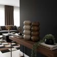 Set of two stacked sculptural decorative vases with rounded segmented silhouettes in natural stone and dark wood finishes. Contemporary statement décor pieces perfect for styling console tables, shelves, or coffee tables with modern organic elegance.