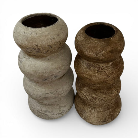 Set of two stacked sculptural decorative vases with rounded segmented silhouettes in natural stone and dark brown finishes. Featuring organic textures and wide openings, these contemporary statement vases add warmth and modern elegance to shelves, console tables, or coffee table displays.