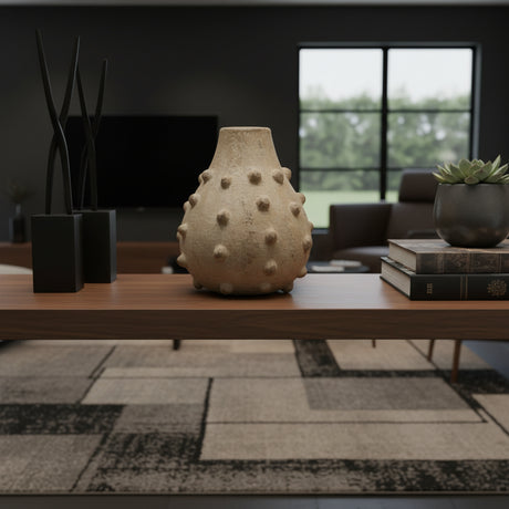 Textured stoneware bobble vase in a natural sand finish, styled on a wooden console table in a contemporary living room. Featuring a rounded silhouette, raised bobble detailing, and an organic handcrafted look, this sculptural vase adds warmth and texture to modern interiors.