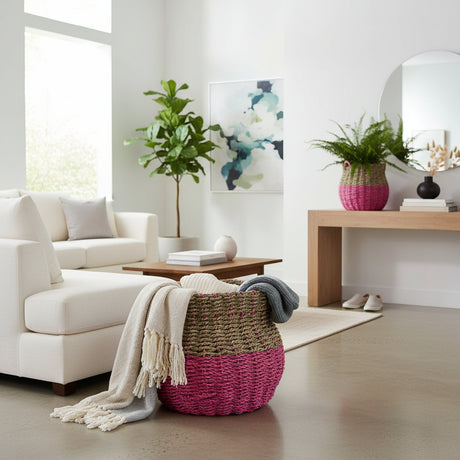 Living room with a white sofa, pink and brown ottoman, and decorative plants.