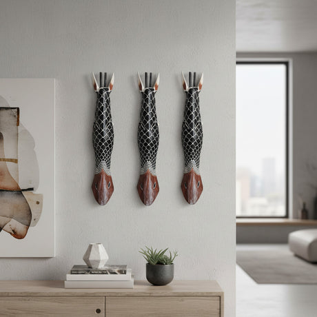 Set of three handcrafted tribal fish wall masks featuring elongated carved designs with black, white, and rich brown finishes. Inspired by traditional African craftsmanship, these decorative wall sculptures add texture, character, and coastal-inspired elegance to living rooms, hallways, and feature walls.