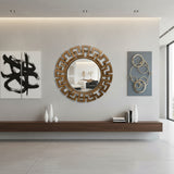 Round walnut-finish geometric wall mirror with a bold Greek key-inspired frame, styled above a floating wooden console in a contemporary living room with modern wall art and minimalist décor.