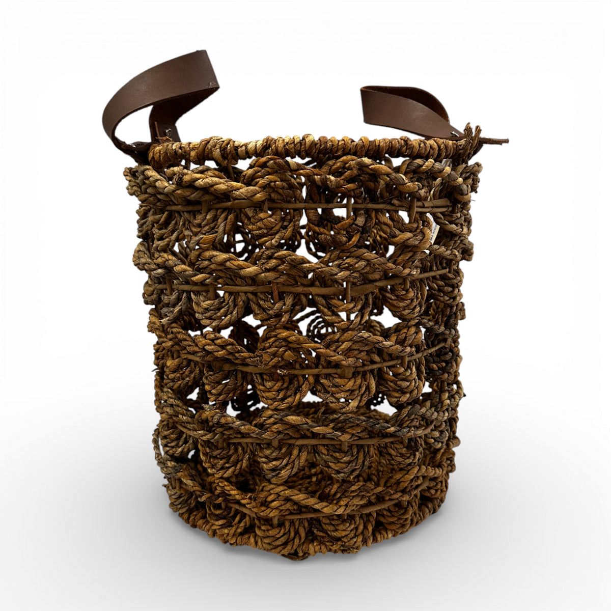 Handcrafted open-weave storage basket with brown leather handles, styled with a soft throw and books for elegant, practical home storage.