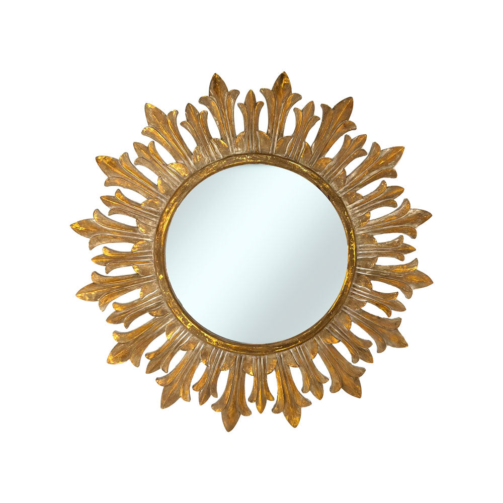 Decorative round wall mirror with an antique gold fleur-inspired sunburst frame featuring elegant leaf-shaped rays and a distressed metallic finish, perfect for adding timeless luxury to any interior.