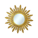Decorative round wall mirror with an antique gold laurel-inspired sunburst frame featuring elegant branching leaf rays and a distressed metallic finish, creating a timeless luxury statement for any interior.