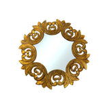 Elegant round wall mirror with an ornate antique gold frame featuring intricate scrollwork and leaf motifs, finished in a distressed metallic gold for a timeless luxury look.