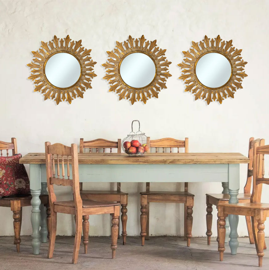 Set of three antique gold sunburst wall mirrors featuring ornate leaf-inspired frames, beautifully displayed above a rustic farmhouse dining table to create an elegant focal point and add warmth and timeless character to the space.