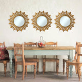 Set of three antique gold sunburst wall mirrors featuring ornate leaf-inspired frames, beautifully displayed above a rustic farmhouse dining table to create an elegant focal point and add warmth and timeless character to the space.