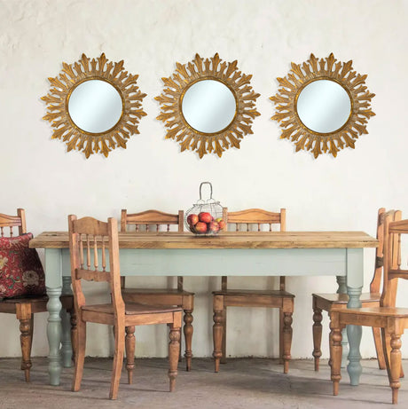 Set of three antique gold sunburst wall mirrors featuring ornate leaf-inspired frames, beautifully displayed above a rustic farmhouse dining table to create an elegant focal point and add warmth and timeless character to the space.