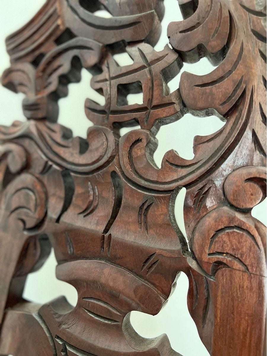 Close-up of a hand-carved dark wood display easel showcasing intricate floral scrollwork, pierced detailing, and a rich antique wood finish crafted by skilled artisans.