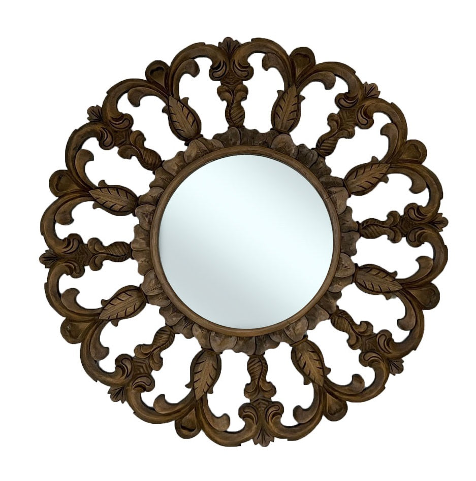 Decorative round wall mirror with a hand-carved dark wood frame featuring intricate floral scrollwork and leaf motifs, bringing timeless elegance and rich natural warmth to classic and traditional interiors.