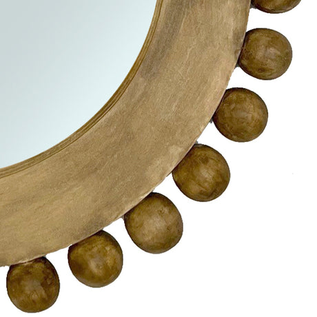 Close-up of a handcrafted round wall mirror with a natural wood frame and decorative beaded detailing, showcasing its warm organic texture and timeless contemporary design.