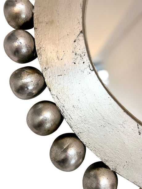 Close-up of a handcrafted silver round wall mirror featuring decorative beaded detailing and a distressed metallic finish, highlighting its elegant craftsmanship and timeless luxury.