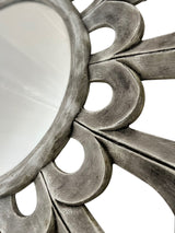 Close-up of a round wall mirror featuring sculptural petal detailing with a distressed silver finish, highlighting its handcrafted texture and elegant decorative design.